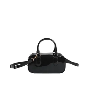 Minimalist black patent leather underarm bag with glossy finish and gold metal hardware