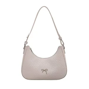 Chic beige woven texture half-moon underarm bag with silver bow accent and adjustable strap