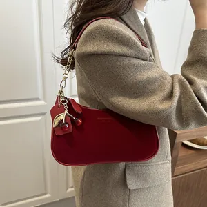 Chic red suede crescent shoulder bag with golden chain and cherry charm detail