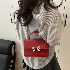 Mini sac carré rouge avec nœud métallique argenté et bandoulière en chaîne