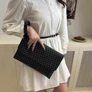 Minimalist flap crossbody bag with circular geometric patterns and a wrist strap in dark grey