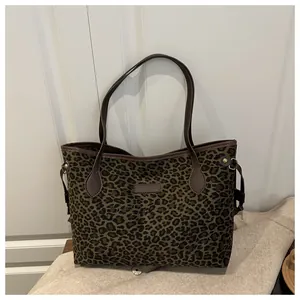Détail du sac cabas imprimé léopard avec anses en cuir marron et texture toile