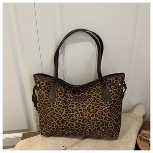Détail d'un sac cabas à imprimé léopard avec anses en cuir marron et boucles en métal doré