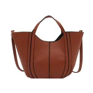 Sac seau minimaliste beige bronzé avec bandes noires et bandoulière élégante