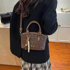 Borsa vintage leopardata con logo dorato e ciondolo elegante in perline di legno