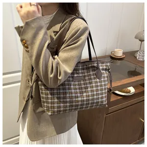 Detail of blue and grey plaid tweed tote bag with premium leather straps and drawstring