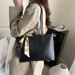 Classic black leather tote bag with elegant floral scarf detail for daily office commuting