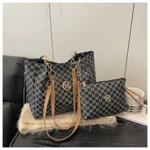 Détail du sac cabas à imprimé monogramme et anses en cuir marron sur bois sombre