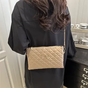 Quilted bow crossbody bag in beige leather worn by a model in a stylish interior setting