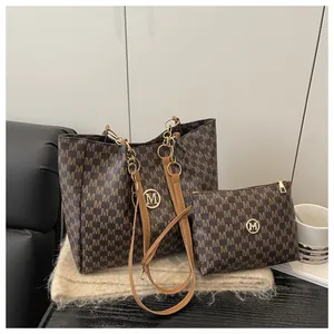 Détails du sac cabas marron à motif M avec logo métallique doré et chaîne décorative