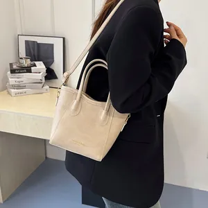 Beige bucket handbag with gold lettering and adjustable shoulder strap for women