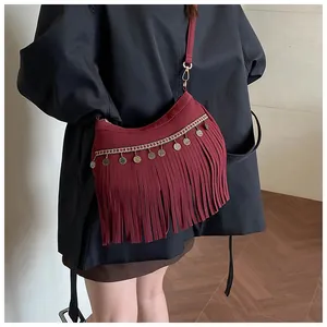 Détail d'un sac bandoulière rouge bordeaux à franges et pampilles de style bohème