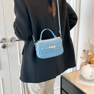 Light blue faux leather mini crossbody bag with gold twist lock and top handle