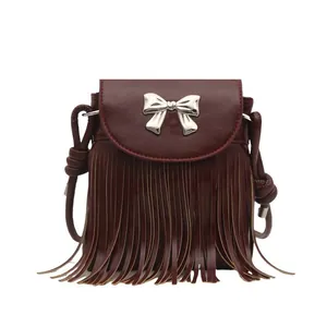 Front view of a burgundy crossbody bag with fringe tassels and a silver bow ornament