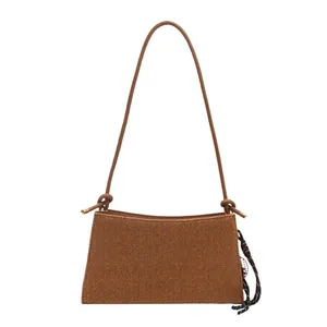 Brown woven shoulder bag for women with minimalist design and stylish knot shoulder strap