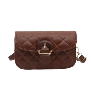 Brown quilted crossbody bag with rhombic pattern and vintage round metal clasp on white background