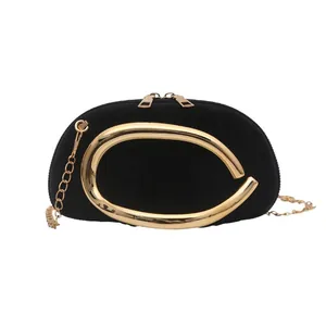 Elegant semi-round black suede handbag with chunky gold metal handle and chain strap