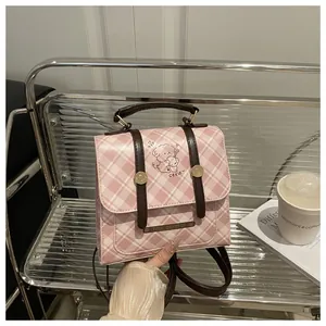 Détail du sac à dos à carreaux roses avec motif chiot et plaque en métal gravée