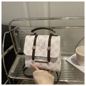 Détail du sac à dos vintage à carreaux avec motif ours et poignées marron de qualité