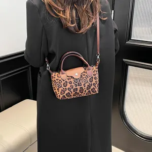 Mini tote bag featuring leopard rose print and top handle shown on fashion model
