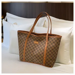 Detail shot of the vintage geometric pattern and leather logo tag on the brown tote bag