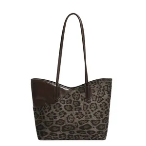 Grote shopper met luipaardprint en donkerbruine lederen handvatten op wit decor