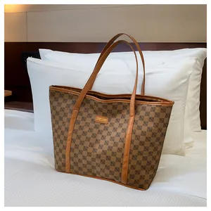 Detailed close-up of brown tote bag with geometric letter pattern and leather label