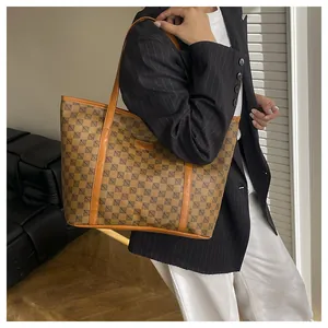 Detail of vintage geometric pattern tote bag with leather strap and fashion brand plate
