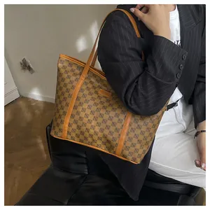 Close-up of brown faux leather tote bag with black geometric print and fashion label