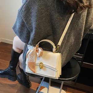 Chic beige square handbag with gold twist lock and bear print silk scarf detail