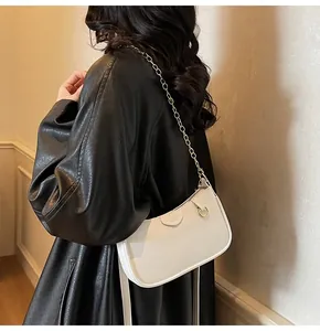 Close-up of white lychee texture underarm bag with elegant gold chain shoulder strap
