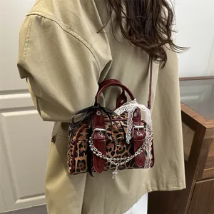 Sac sous le bras léopard rétro avec chaînes métalliques et nœuds sur un manteau kaki