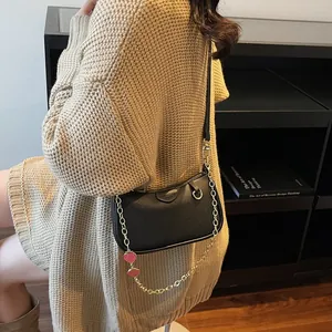 Vintage black lychee leather underarm bag with gold chain and strawberry charms on model