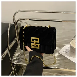 Detailaufnahme von schwarzem Samt-Steppmuster und edler goldener Metallschnalle der Tasche