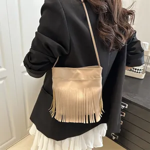 Minimalistische beige Fransen-Umhängetasche mit feinen Quasten am Modell für den Alltag