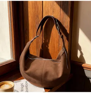 Dettaglio borsa tote in pelle scamosciata marrone vintage su davanzale soleggiato