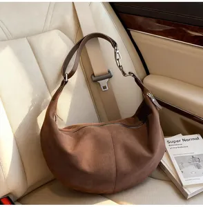 Dettaglio della borsa hobo in pelle scamosciata marrone con catena d'argento e cuciture