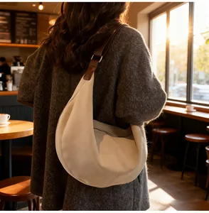 Dettaglio della borsa a mezzaluna in camoscio beige con tracolla in pelle marrone
