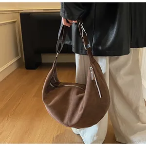 Dettaglio della borsa hobo marrone vintage con texture scamosciata opaca e cerniera argentata