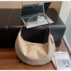 Dettaglio borsa a mezzaluna in pelle opaca con grande capacità e texture scamosciata