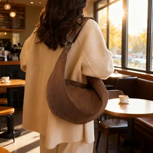 Borsa hobo vintage in pelle scamosciata marrone indossata da modella in interno