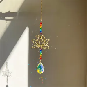 Detail of crystal suncatcher with golden lotus and rainbow beads casting light