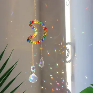 Macro view of crystal moon suncatcher creating rainbow light reflections on the wall