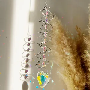 Détail d'un attrape-soleil en spirale avec perles de cristal et grand pendentif en cœur