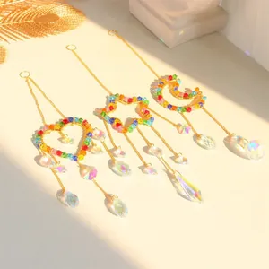 Detail of three suncatchers with heart, star, and moon crystals reflecting natural sunlight