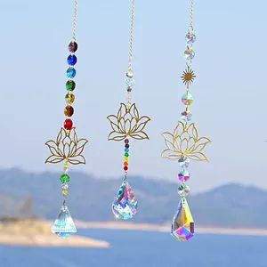 Drei Kristall-Sonnenfänger mit goldenen Lotus-Anhängern und Chakra-Perlen vor Seehintergrund