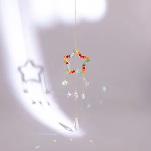 Golden star suncatcher with colorful crystals and prisms creating a rainbow light effect