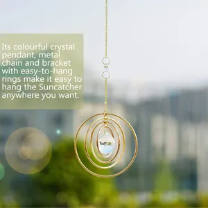 Detail of hanging crystal suncatcher with gold metal rings and faceted pendant charms