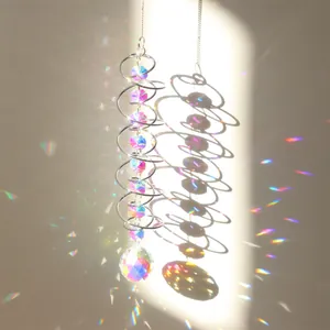 Macro detail of silver spiral suncatcher with colorful crystals casting rainbow light