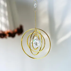 Golden galaxy suncatcher with concentric rings and faceted crystal ball pendant